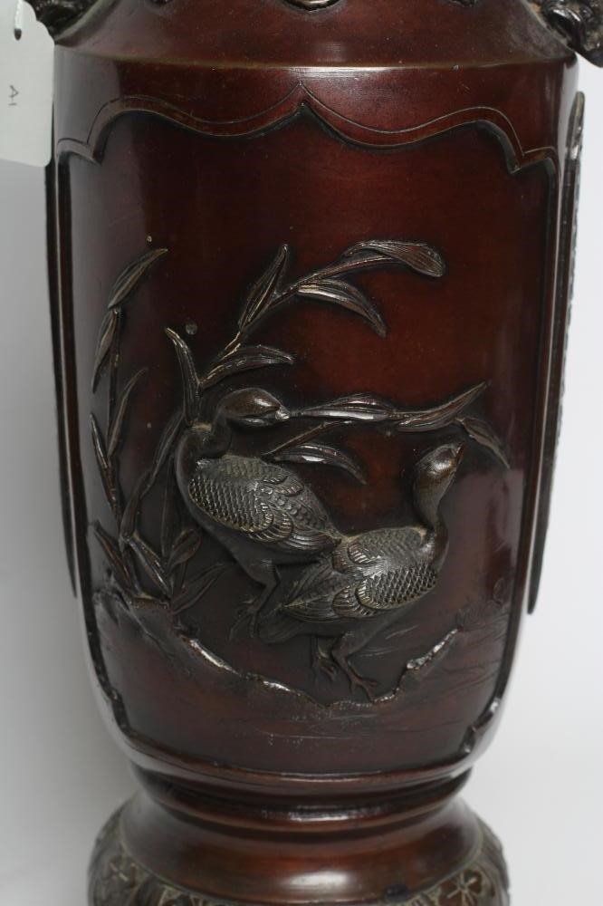 A JAPANESE BRONZE VASE of cylindrical form with two dolphin handles, cast in relief with wading Image
