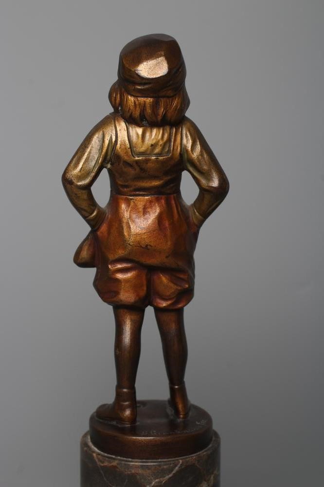 B. GRUNDMANN - An Art Deco bronze figure cast as a young boy with carved ivory face wearing a cap on Image
