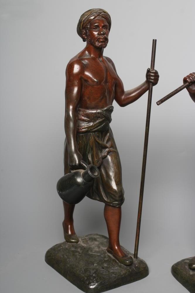 A PAIR OF PAINTED SPELTER ARAB MALE WATER CARRIERS, after Marcel Debut (1865-1933) each modelled Image