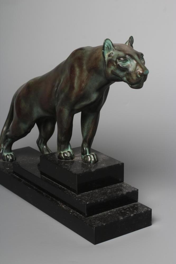 AN ART DECO BRONZED SPELTER LIONESS modelled standing with alert expression, green patination, Image
