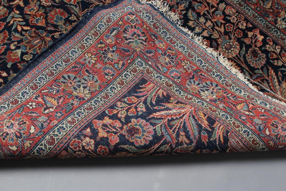 A PERSIAN RUG, 20th century, the navy blue mirhab with vase and flowers, red and ivory floral Image