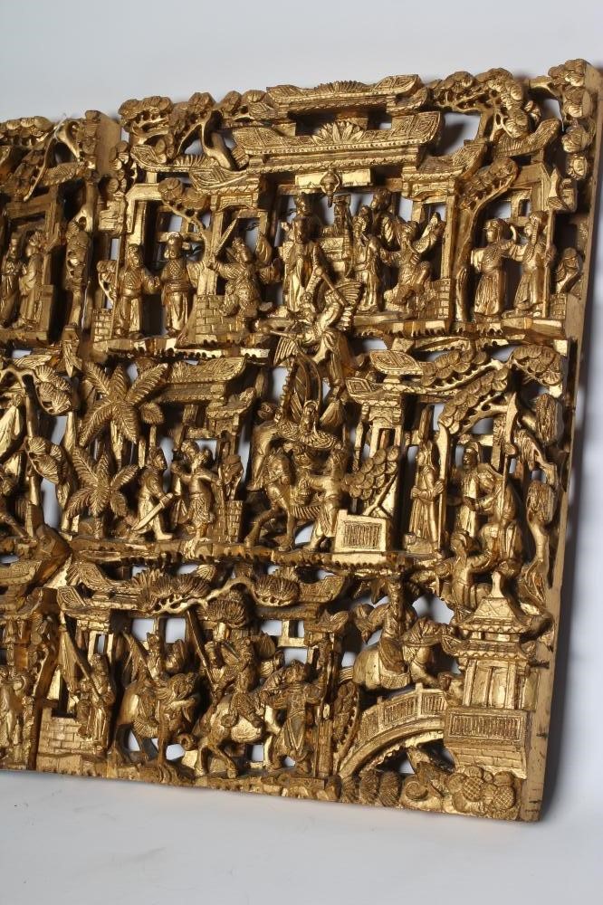 A PAIR OF CHINESE CARVED AND PIERCED GILTWOOD PANELS, c.1900, of oblong form with figures in a Image