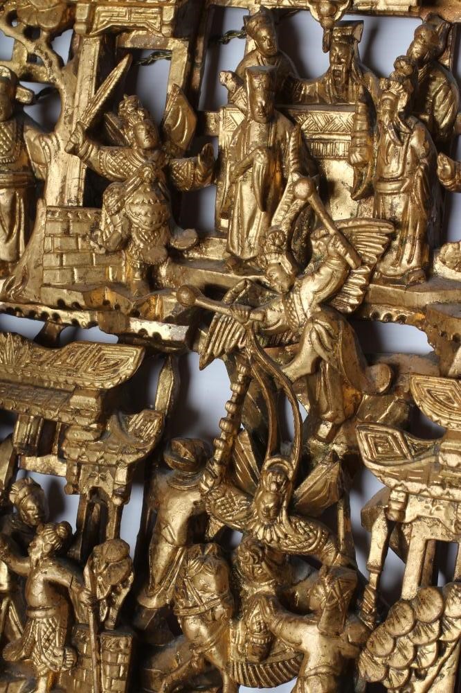 A PAIR OF CHINESE CARVED AND PIERCED GILTWOOD PANELS, c.1900, of oblong form with figures in a Image