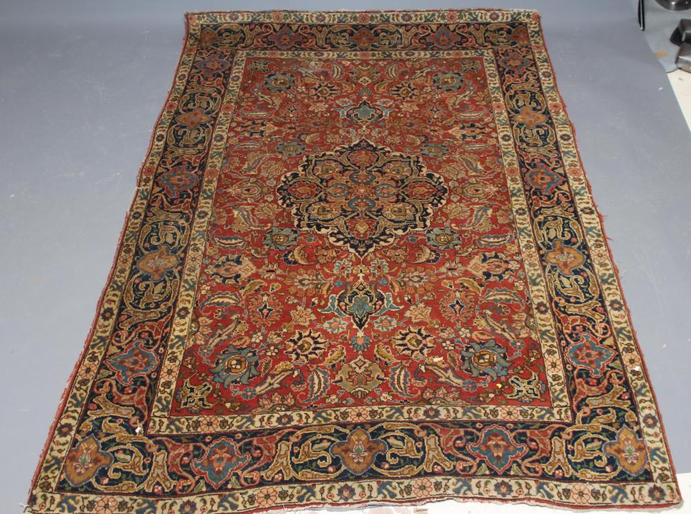 A PERSIAN RUG, early 20th century, the red floral field with central navy blue gul, navy blue main Image