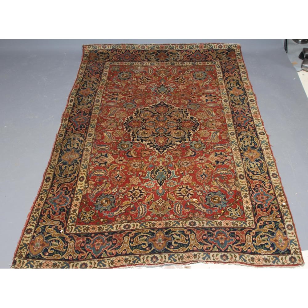 A PERSIAN RUG, early 20th century, the red floral field with central navy blue gul, navy blue main Image
