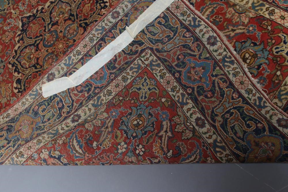 A PERSIAN RUG, early 20th century, the red floral field with central navy blue gul, navy blue main Image