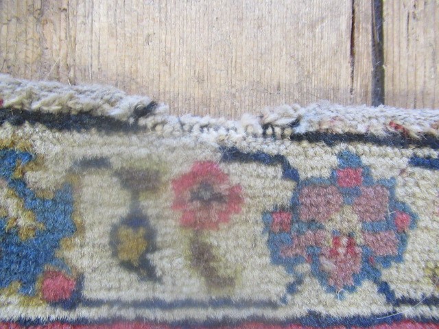 A PERSIAN RUG, early 20th century, the red floral field with central navy blue gul, navy blue main Image