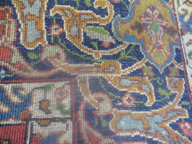 A PERSIAN RUG, early 20th century, the red floral field with central navy blue gul, navy blue main Image