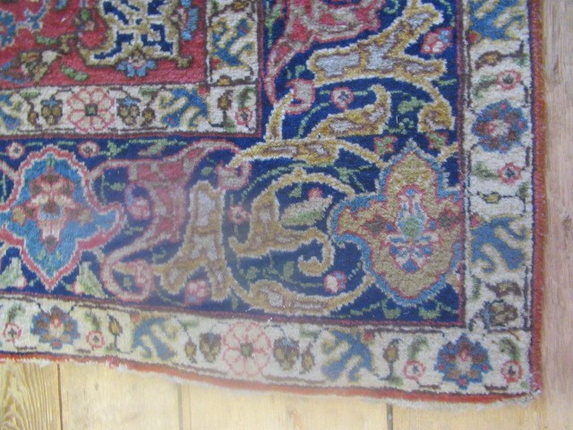 A PERSIAN RUG, early 20th century, the red floral field with central navy blue gul, navy blue main Image