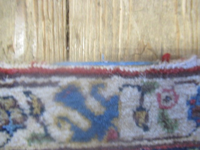 A PERSIAN RUG, early 20th century, the red floral field with central navy blue gul, navy blue main Image