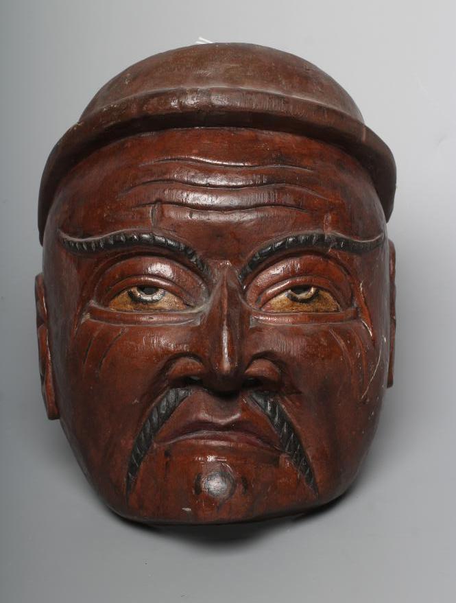 A JAPANESE CARVED WOOD NOH MASK painted in red, black and white, with holes for the eyes and Image