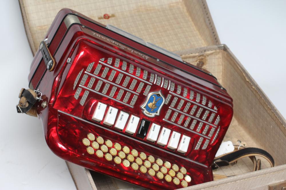 A PAOLO SOPRANI BUTTON ACCORDIAN with red marbled effect case, leather strapping and hard case (Est. Image