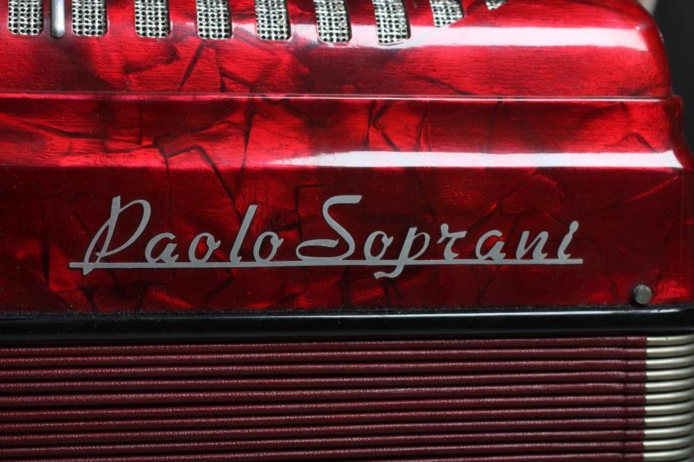 A PAOLO SOPRANI BUTTON ACCORDIAN with red marbled effect case, leather strapping and hard case (Est. Image