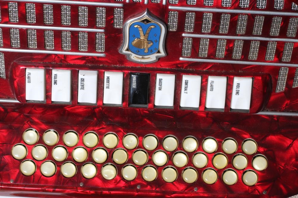 A PAOLO SOPRANI BUTTON ACCORDIAN with red marbled effect case, leather strapping and hard case (Est. Image