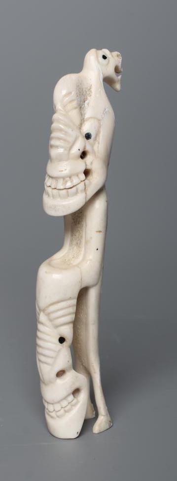 A CARVED INUIT TOTEM, made of polar bear bone, from Kulusuk-Kap Dam, Greenland, with three faces and Image
