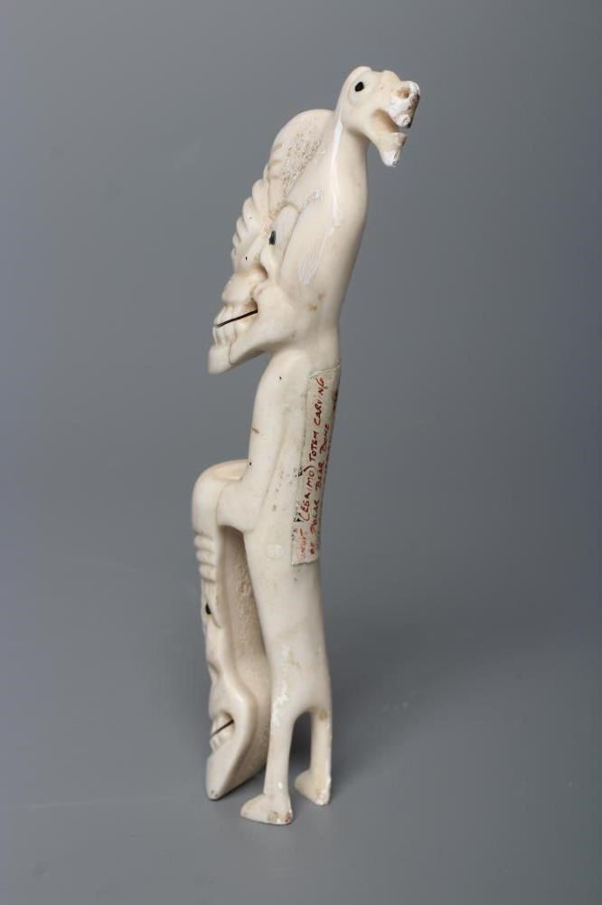A CARVED INUIT TOTEM, made of polar bear bone, from Kulusuk-Kap Dam, Greenland, with three faces and Image