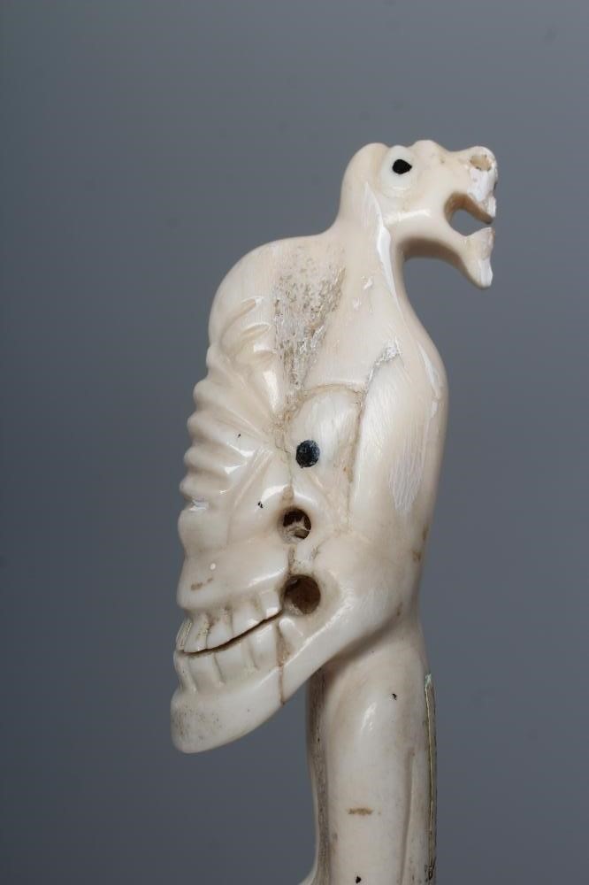 A CARVED INUIT TOTEM, made of polar bear bone, from Kulusuk-Kap Dam, Greenland, with three faces and Image