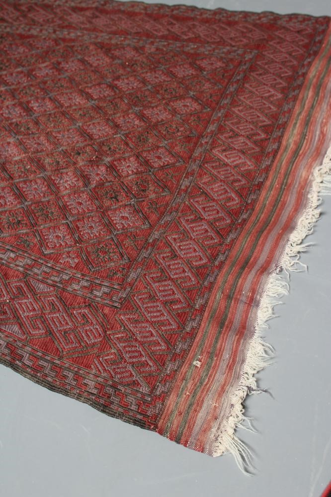 A PERSIAN TRIBAL RUG, the soft red ground with trellis patterned field in shades of grey, within a Image