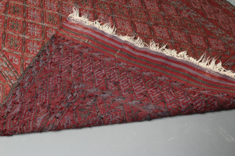 A PERSIAN TRIBAL RUG, the soft red ground with trellis patterned field in shades of grey, within a Image