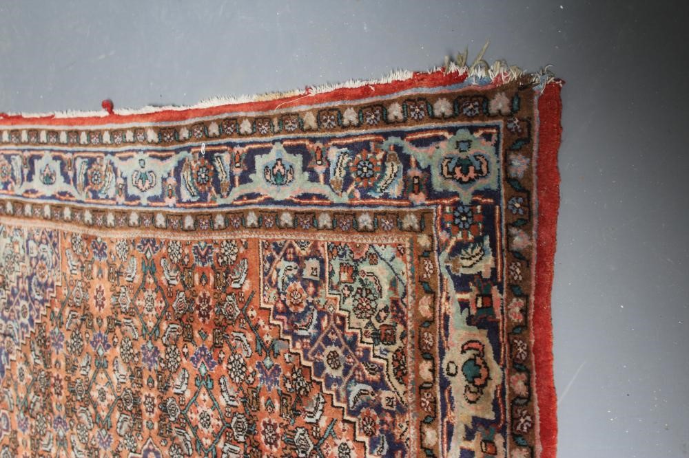 A PERSIAN RUG, 20th century, the red floral field with navy blue centre gul and spandrels, with navy Image