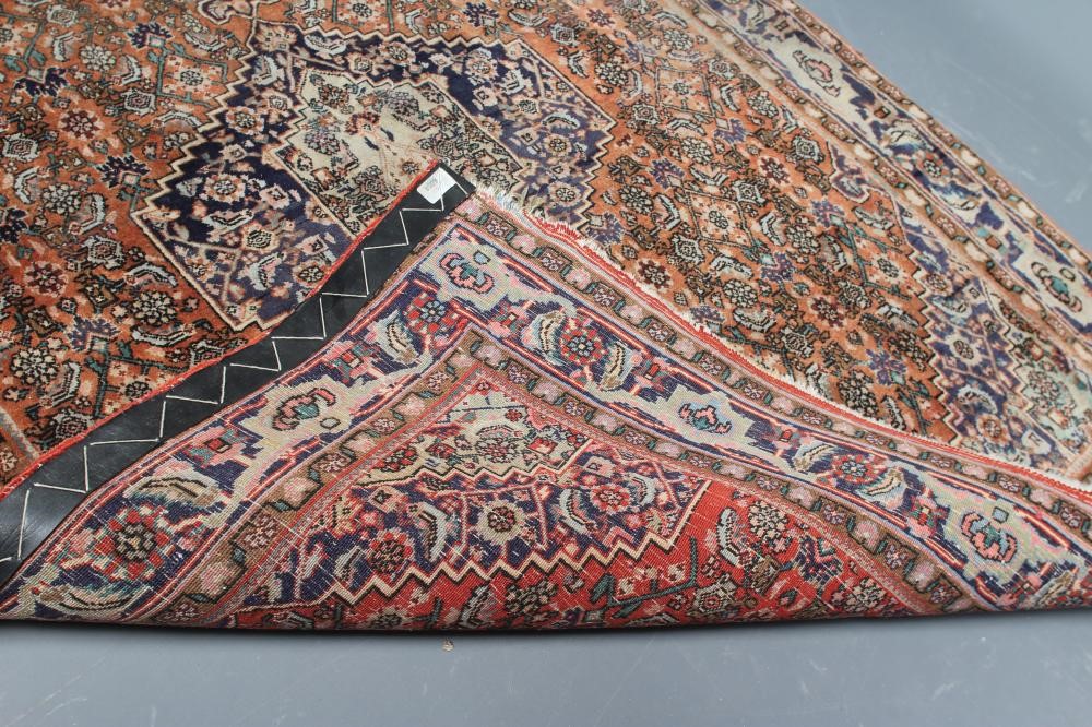 A PERSIAN RUG, 20th century, the red floral field with navy blue centre gul and spandrels, with navy Image