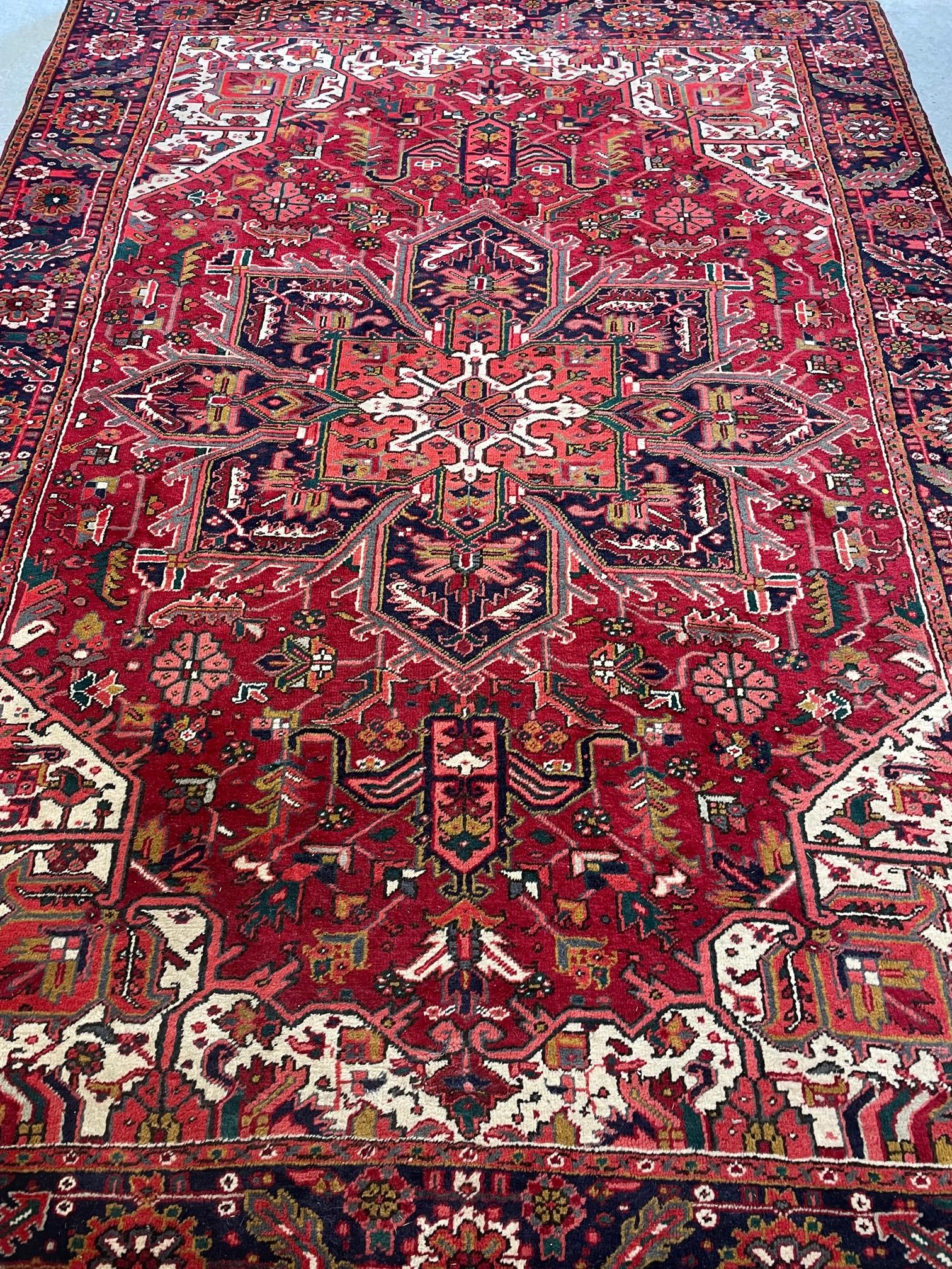 A PERSIAN CARPET, modern, the red floral field with large navy blue central gul and ivory corners, Image