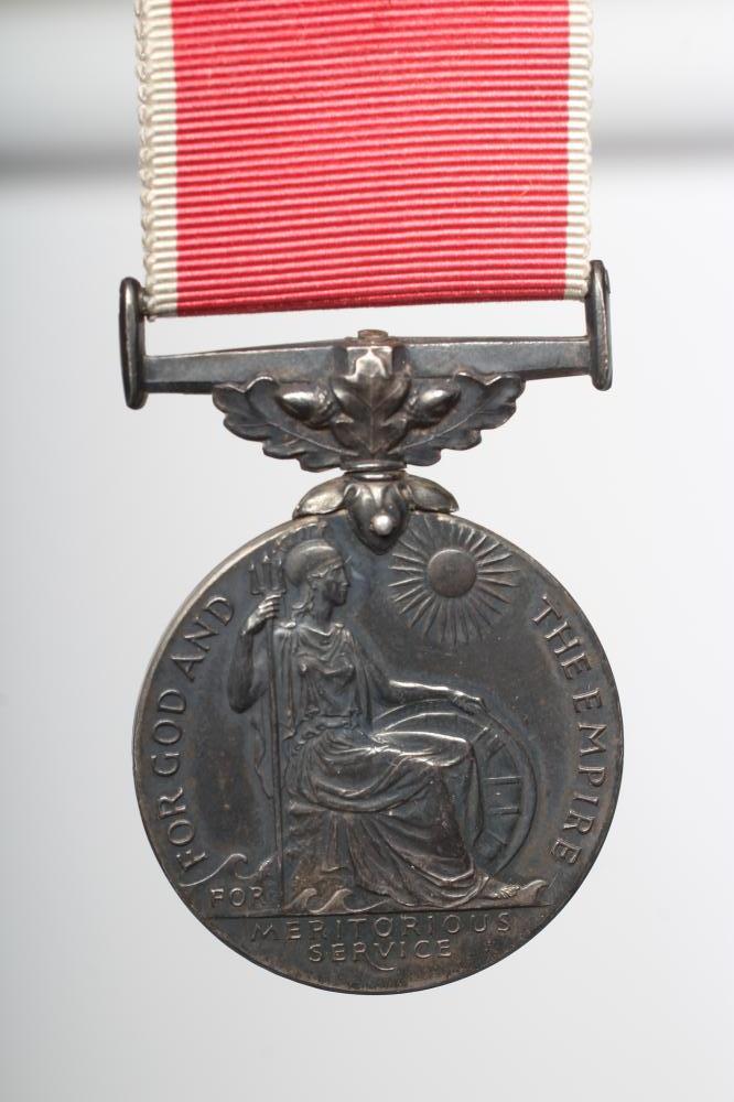 AN EMPIRE MEDAL with George V monogram and red ribbon with white edges, named "THOMAS LITTLE" (Est. Image