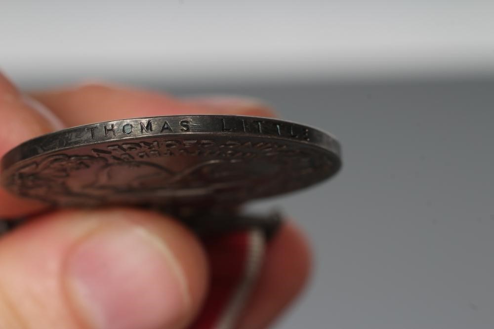 AN EMPIRE MEDAL with George V monogram and red ribbon with white edges, named "THOMAS LITTLE" (Est. Image