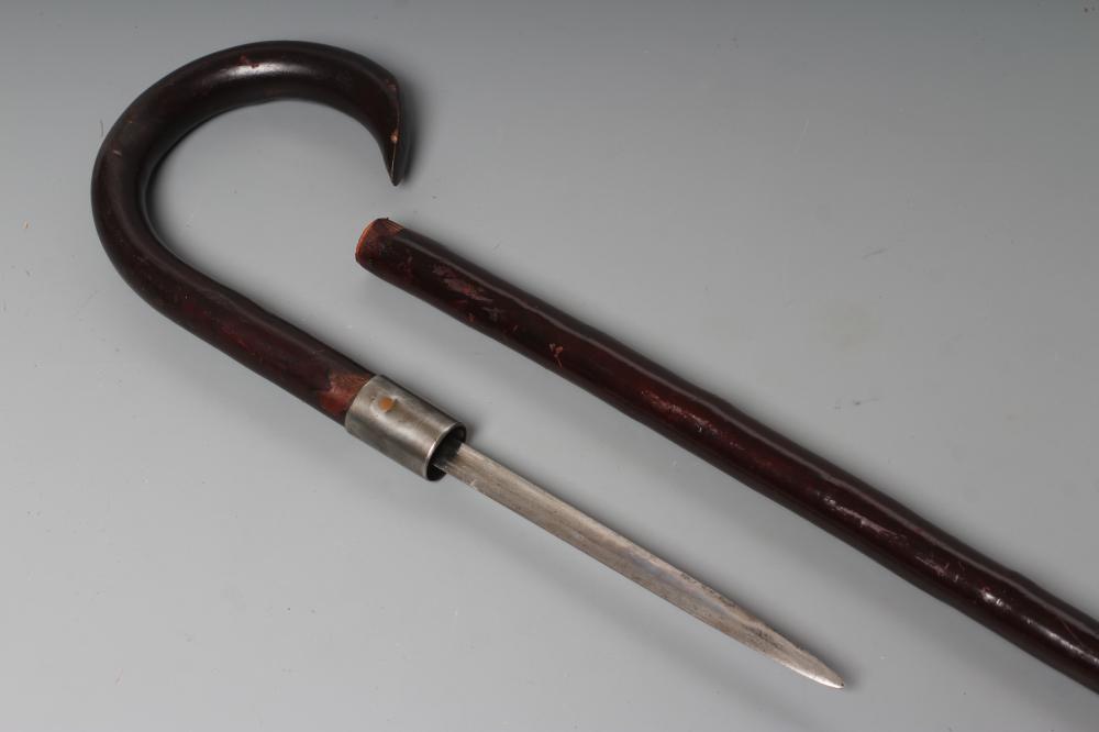 A SWORD STICK, early 20th century, with 5 1/2" double edged blade, metal ferrule and crooked handle, Image