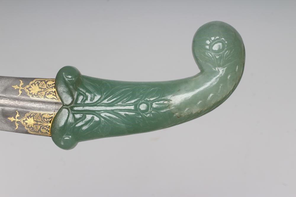 A MUGHAL TYPE DAGGER, the 10 1/8" serpentine blade inlaid with gold metal flowers, the typical jade Image