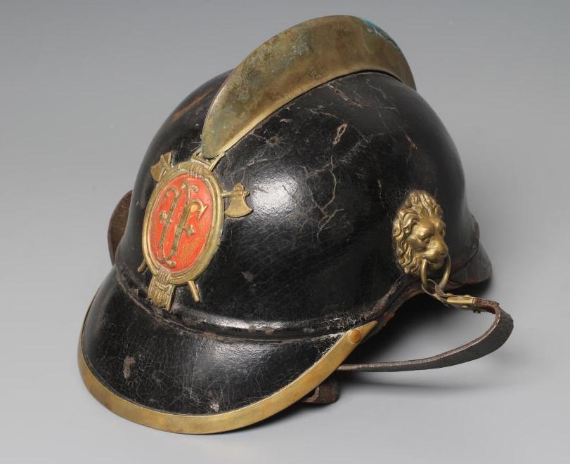 AN AUSTRIAN FIREMAN'S LEATHER HELMET with brass crest, badge, lion head bosses and leather chin Image