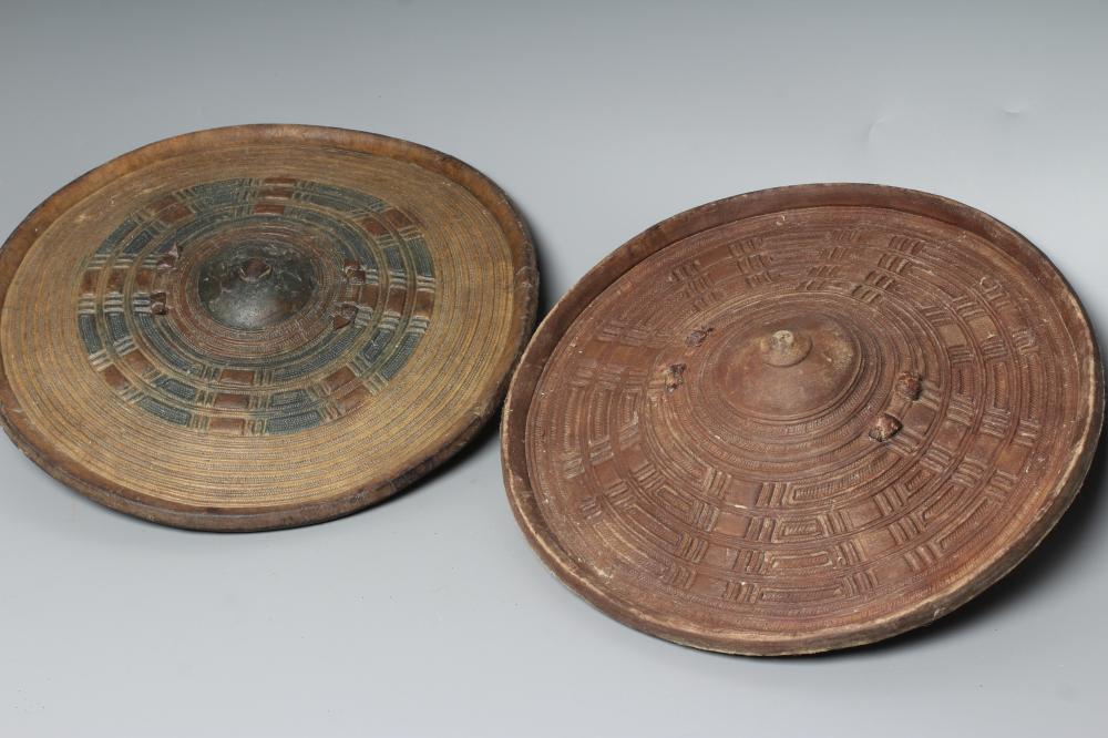 TWO AFRICAN HIDE SHIELDS, possibly Somalian, of circular form, with embossed geometric design and Image