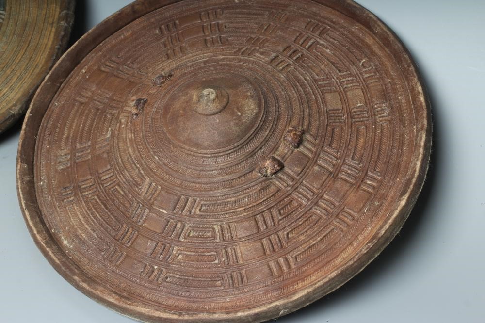 TWO AFRICAN HIDE SHIELDS, possibly Somalian, of circular form, with embossed geometric design and Image