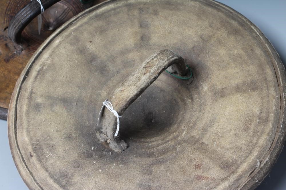 TWO AFRICAN HIDE SHIELDS, possibly Somalian, of circular form, with embossed geometric design and Image