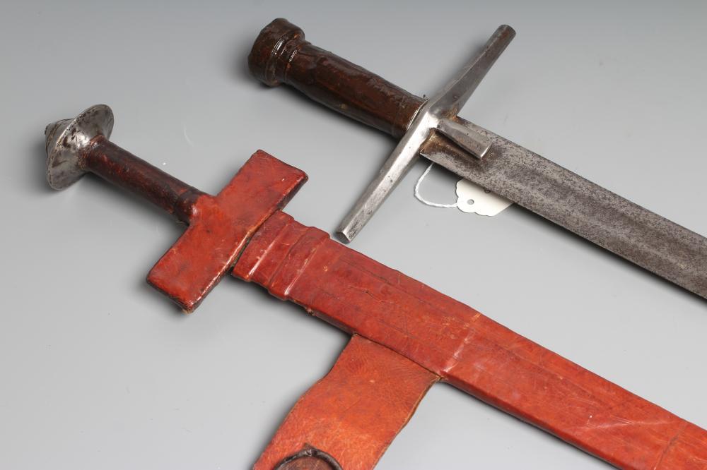 TWO AFRICAN HAUSA SWORDS comprising one of typical form with steel crossguard and leather grip, and Image