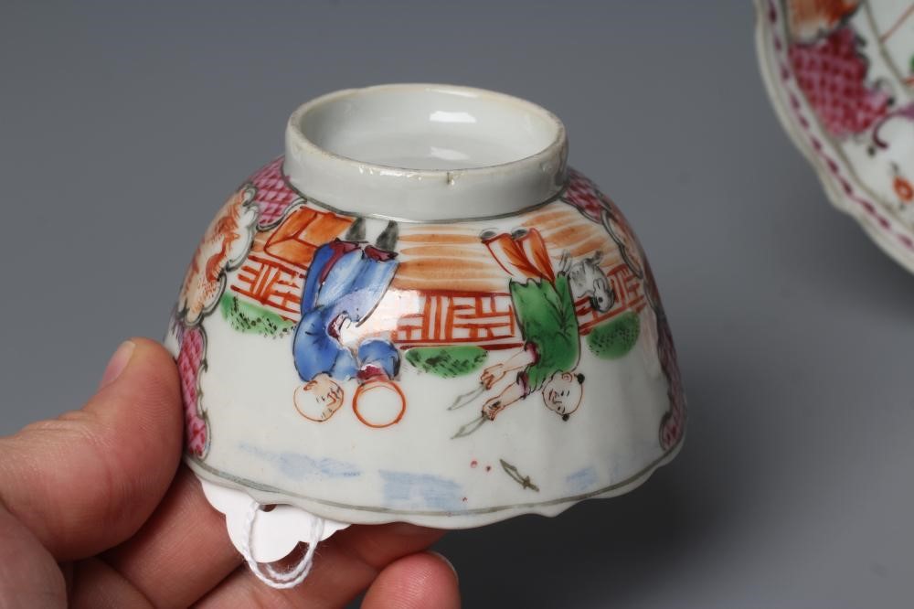 A CHINESE PORCELAIN FAMILLE ROSE TEA BOWL AND SAUCER painted with a tightrope walker and a knife Image