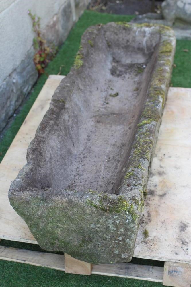 A SANDSTONE TROUGH of rough hewn narrow oblong form, 58" x 16" x 11" (Est. plus 24% premium inc. Image