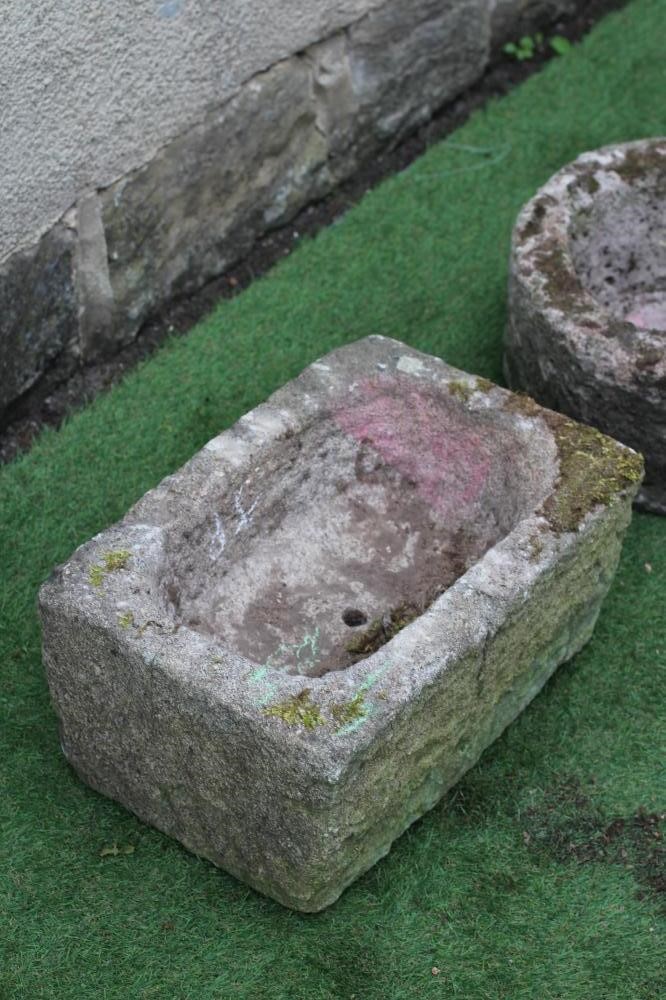A SANDSTONE TROUGH of rough hewn circular form, 15 1/2" x 8", together with another of oblong form, Image
