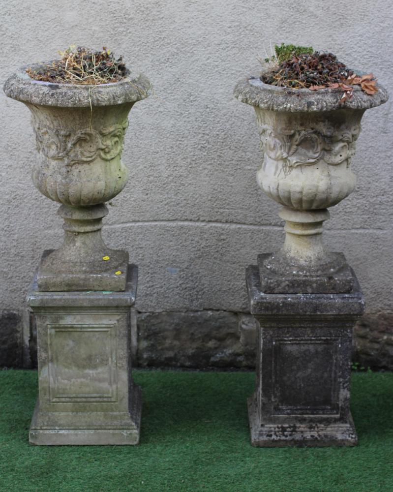 A PAIR OF CAST STONE URNS of half fluted campana form with ovolu moulded rim Image