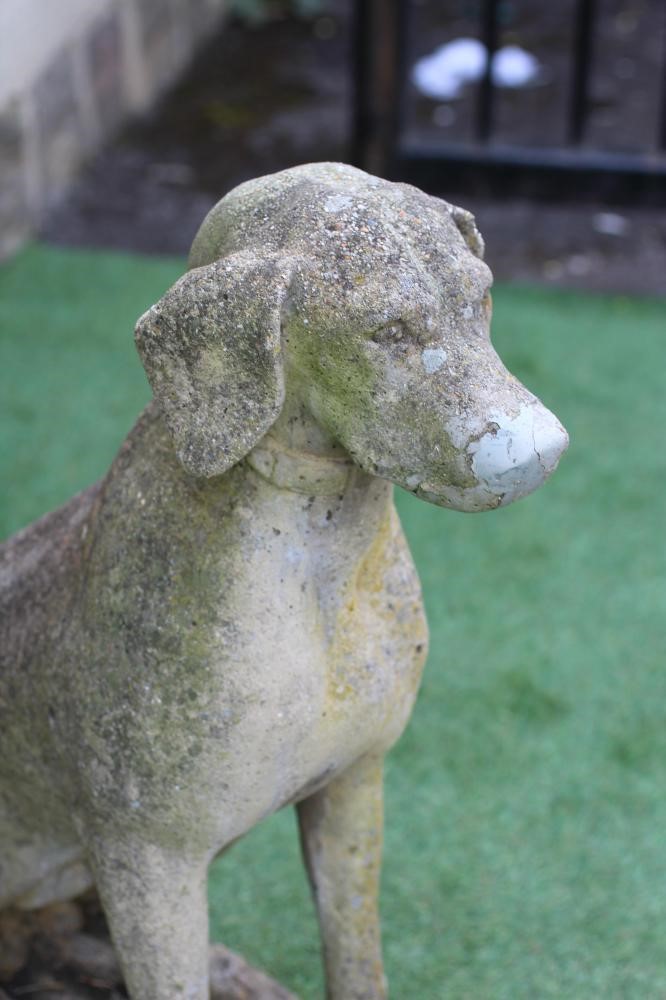 A CAST STONE FIGURE OF A SEATED DOG on an oblong plinth, 18" x 27 1/4" (Est. plus 24% premium inc. Image