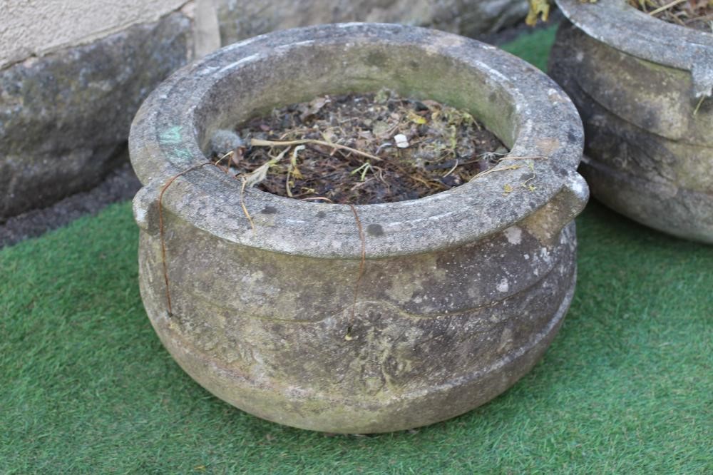 A PAIR OF CAST STONE PLANTERS of cauldron form, the moulded rim with three handles over a band of Image