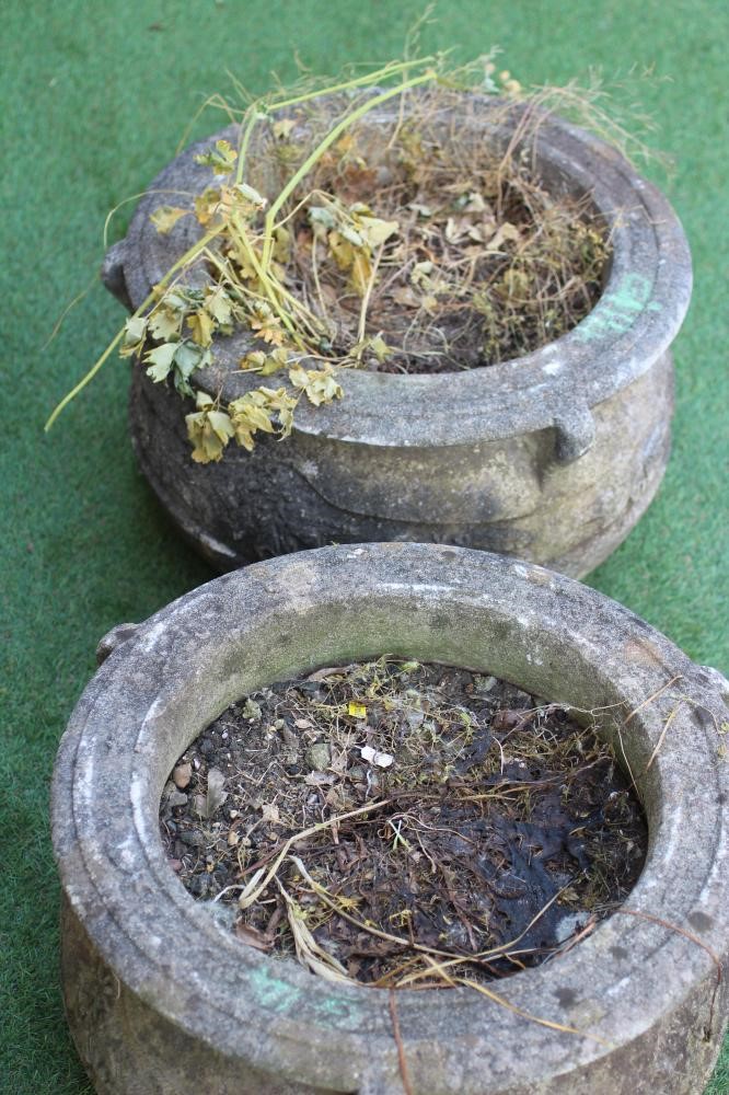 A PAIR OF CAST STONE PLANTERS of cauldron form, the moulded rim with three handles over a band of Image