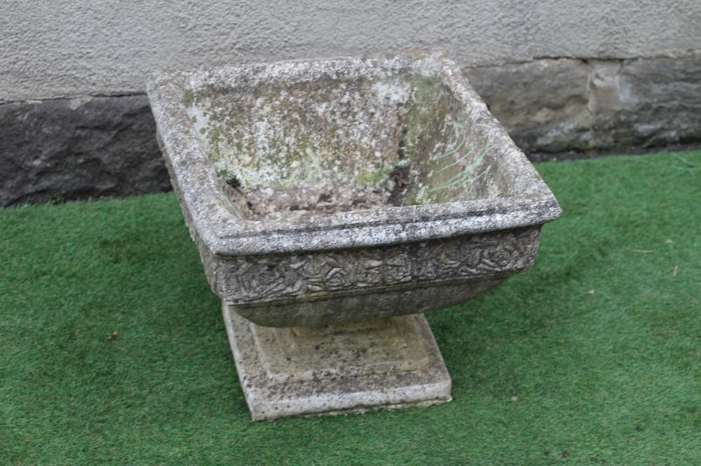 A CAST STONE PLANTER of square form with moulded rim over a band of flower heads, raised on a Image