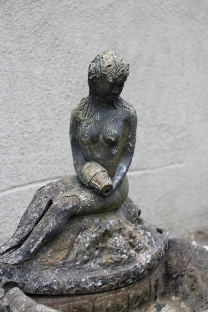 A CAST STONE WATER FEATURE modelled as an escallop shell surmounted by a seated nymph with water Image