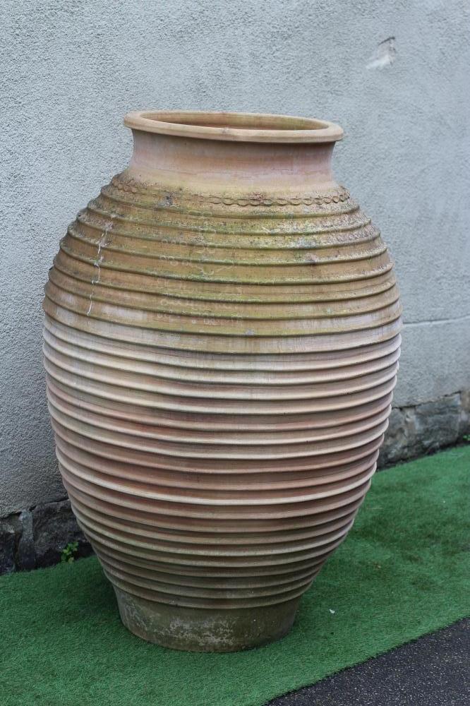 A LARGE TERRACOTTA OLIVE JAR of ovoid form with ribbed banding, 55" high (Est. plus 24% premium inc. Image