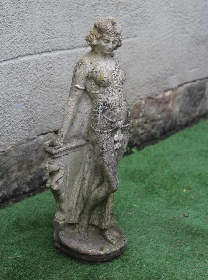 A CAST STONE FIGURE OF AN ODALESQUE modelled standing and leaning against a plinth, 30 3/4" high Image