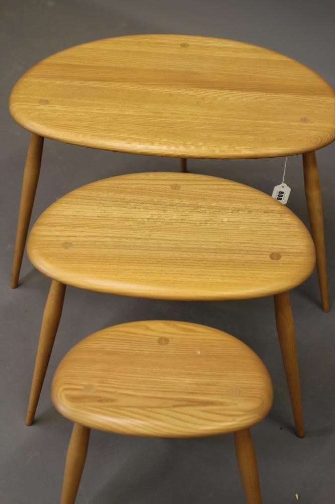 A nest of ercol model 354 elm "pebble" tables, raised on turned beech