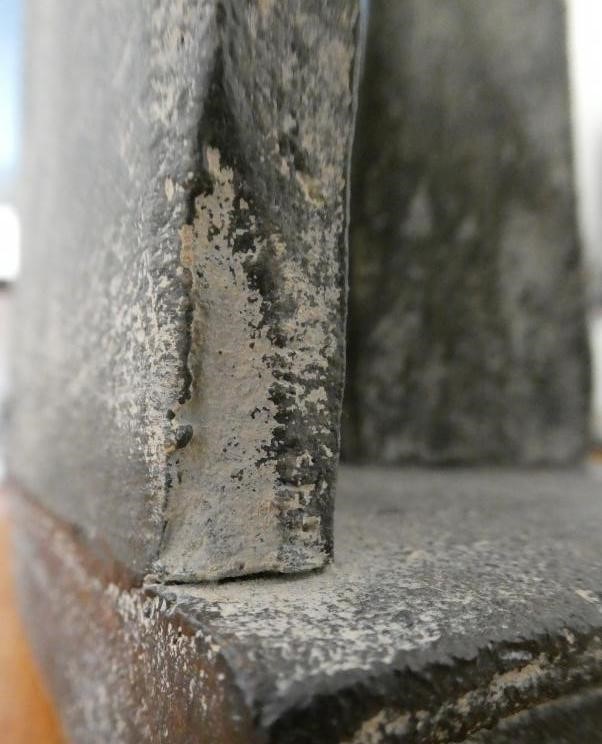 JOHN MALTBY (1936-2000) - a matt grey stoneware sculpture of two figures standing before a cut slab Image