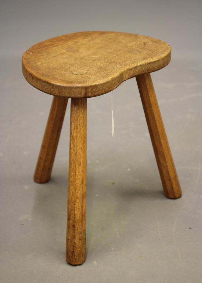 ALBERT JEFFRAY, AN ADZED OAK STOOL, of kidney form raised on three faceted splayed legs, incised Image