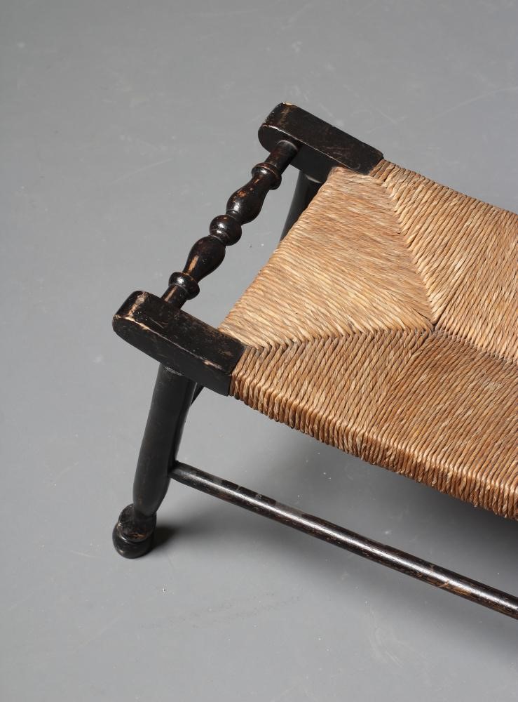 AN ARTS AND CRAFTS EBONISED RUSH SEATED STOOL Image